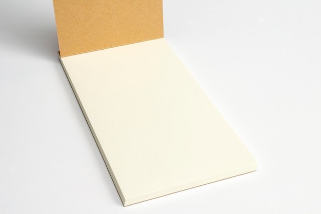 Closeup of opened diary with cardboard hardcover and blank pages isolated on white.