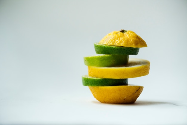 Free photo closeup of oranges mixed with lime pieces isolated on white