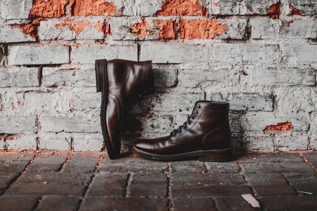 A closeup of a pair of classic shoes on a brick wall