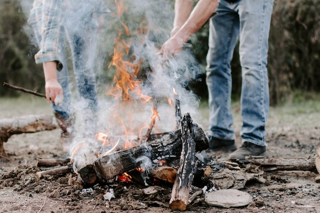 Free photo closeup of people making a bonfire in the forest