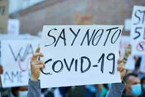 Free photo closeup of person holding banner with say no to covid19 inscription on a protest during coronavirus epidemic