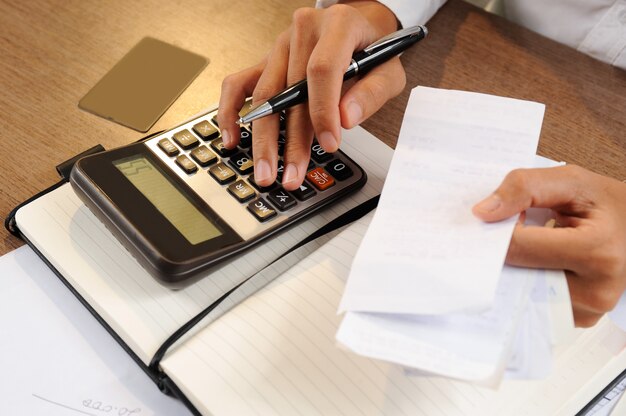 Closeup of person holding bills and calculating them