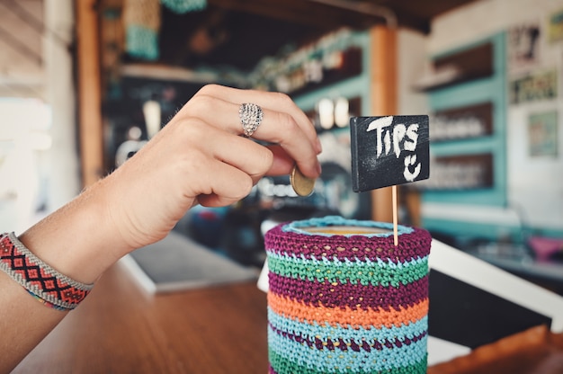 Free photo closeup of a person tipping in a coffee shop under the lights