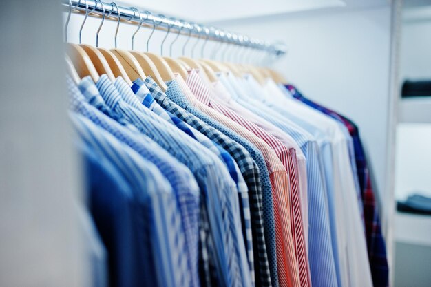 Closeup photo of fashionable clothes on hangers in the shop