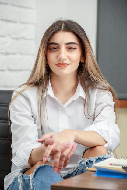 Closeup photo of a young girl sitting at the office High quality photo