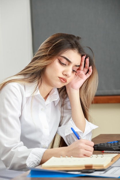 Closeup photo of young lady sitting at desk and working