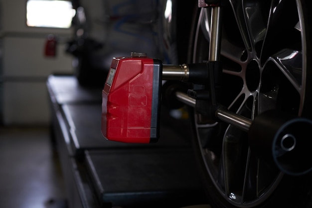 Closeup photoshoot of process or tyre balancing at dark auto service.