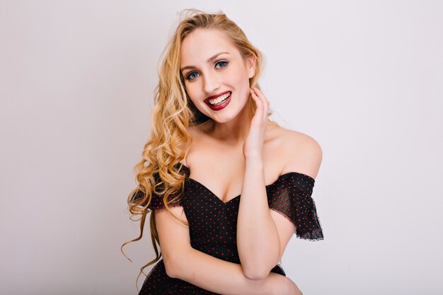 Closeup portrait of beautiful blonde woman with pretty smile, perfect teeth, blue eyes and makeup