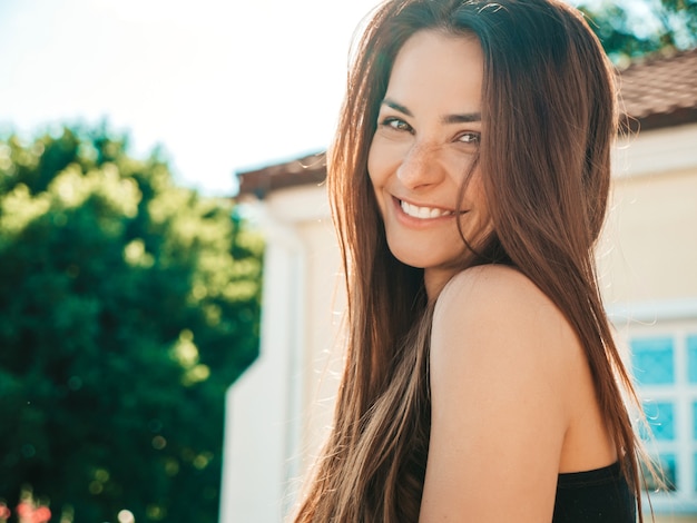 Closeup portrait of beautiful smiling brunette model. Trendy female posing in the street