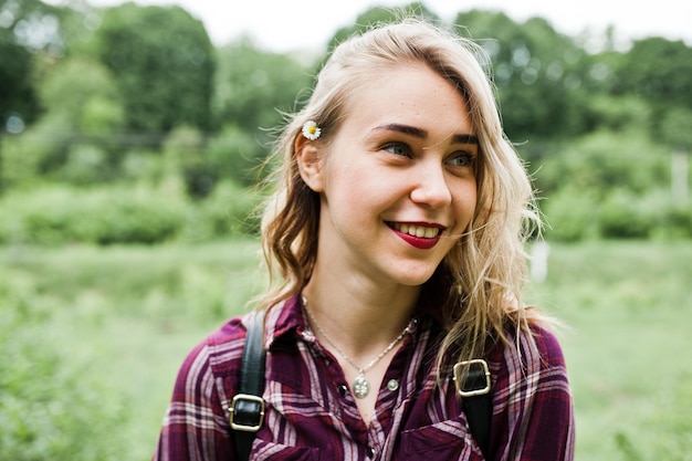 Free photo closeup portrait of a smiling blond girl in tartan shirt in the countryside