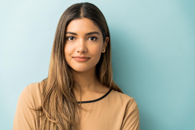 Free photo closeup of pretty young woman with long hair standing against isolated background