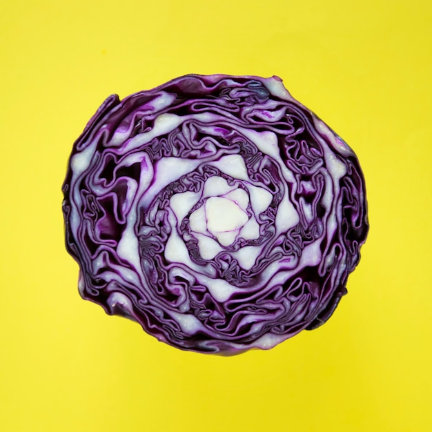 Free Photo closeup of purple round cabbage cut in half in a yellow background