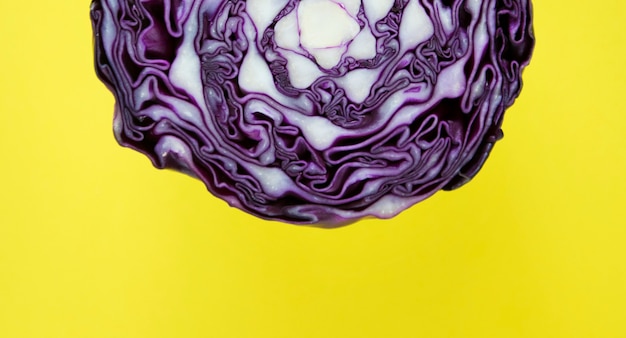 Free Photo closeup of purple round cabbage cut in half in a yellow background