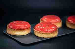 Free photo closeup of red pastry tarts on a black background