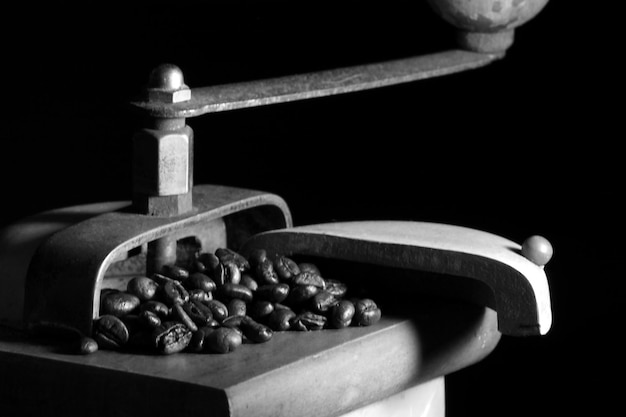 Free photo closeup of roasted coffee beans in an old coffee grinder against a black backgrou