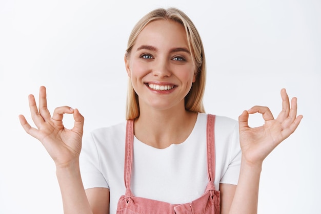 Closeup satisfied blond woman encourage friend dont give up like awesome result thinks everything excellent show okay ok no problem gesture and smiling in agreement being supportive