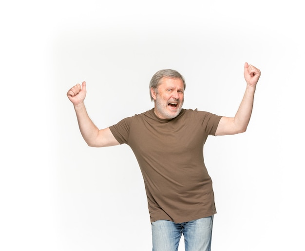 Closeup of senior man's body in empty brown t-shirt isolated on white.