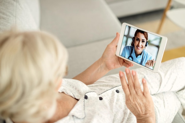 Free photo closeup of senior woman having video call with her doctor over a touchpad