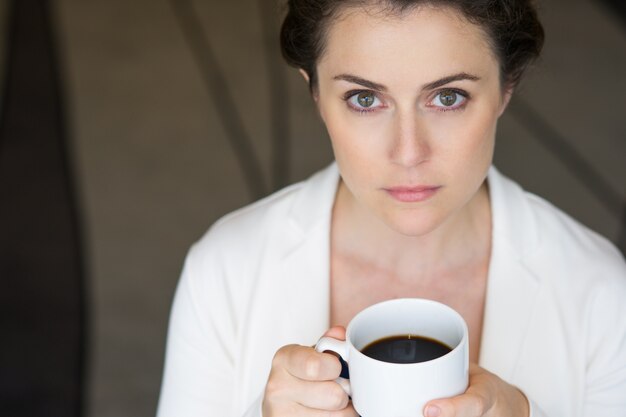 Closeup of Serious Nice Businesswoman with Coffee