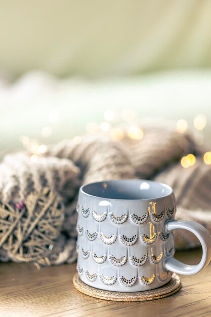 Free Photo closeup shiny gray cup on a blurred background with a knitted element