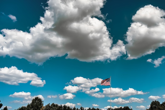 Closeup shot of the American flag waving in the air under a cloudy sky