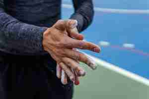 Free photo closeup shot of an athlete putting chalk on his hands - sports concept