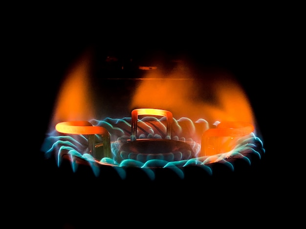 Closeup shot of a beautiful blue-green flame in a gas stove