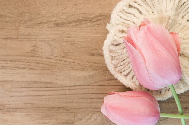 Closeup shot of beautiful pink tulips on wooden background