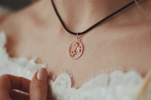 Free Photo closeup shot of a bride wearing a pendant necklace with a black cord