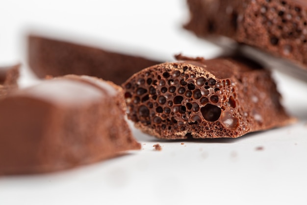 Free photo closeup shot of bubble chocolate pieces isolated on a white surface