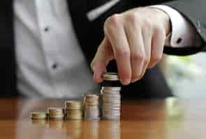 Free photo closeup shot of a businessman's hands counting stacks of coins after business success