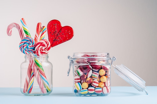 Closeup shot of candy canes and other candies in glass jars