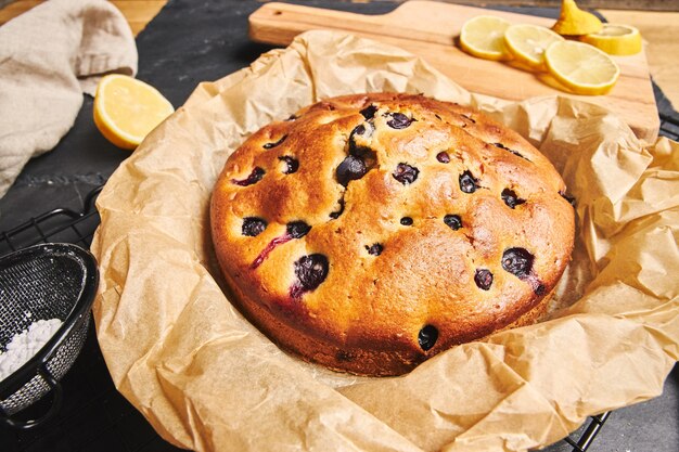 Closeup shot of a Cherry Cake with sugar powder and ingredients on the side on black