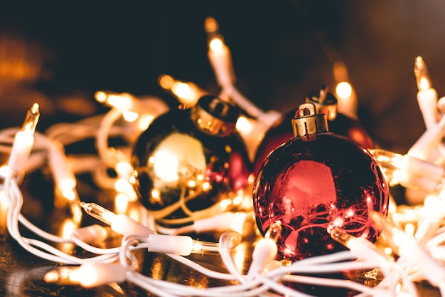 A closeup shot of Christmas ornaments surrounded by tree lights