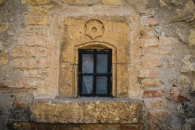 Free photo closeup shot of a closed window on a yellow stone wall