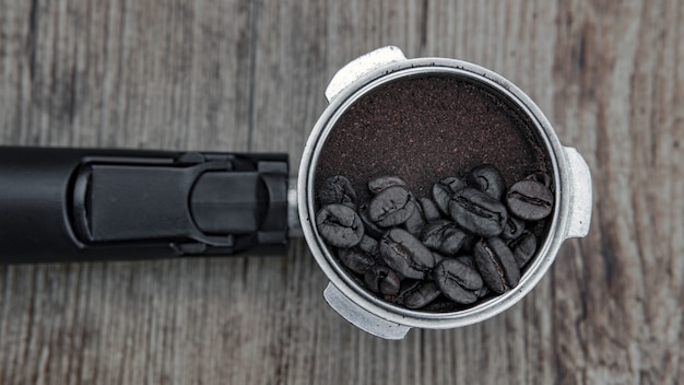 Free photo closeup shot of coffee beans on a coffee powder  - great for background or blog