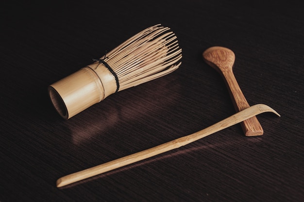 Free photo closeup shot of a cooking brush with wooden spoons on a black background