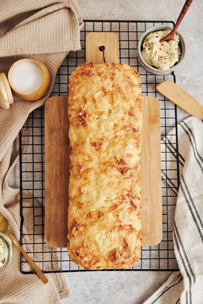 Closeup shot of delicious cheese bread with herb butter on a white table