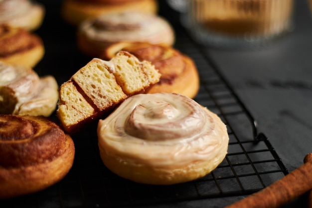 Closeup shot of delicious Cinnamon Rolls with White Glaze on a black table