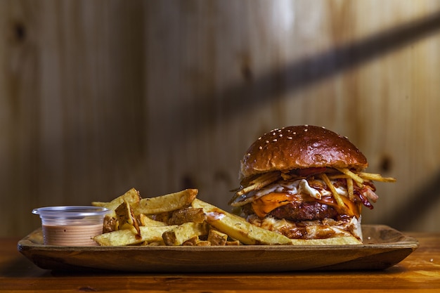 Closeup shot of a delicious hamburger with french fries on the table