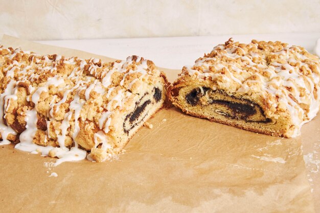 Closeup shot of delicious poppy seeds cake with a white sugar glaze on a white table