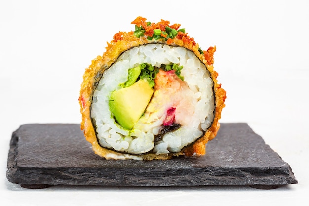 Closeup shot of delicious sushi roll with seasonings on white background