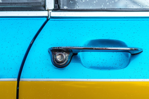 Closeup shot of the door handle of a blue and yellow car