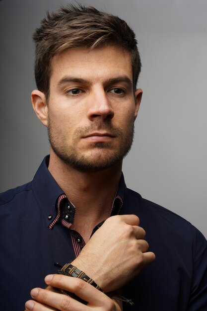 Closeup shot of a fashionable handsome male in a blue classic shirt