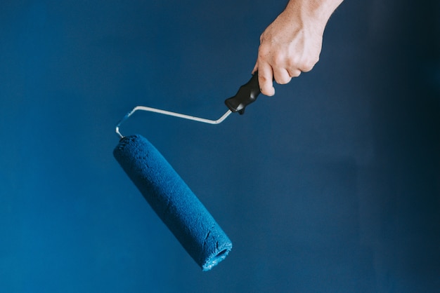 Free photo closeup shot of a female using paint rollers with the color blue