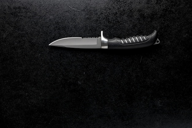 Free photo closeup shot of a fixed sharp knife on a black table