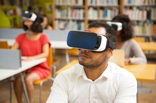 Closeup shot of focused young guy with virtual reality headset