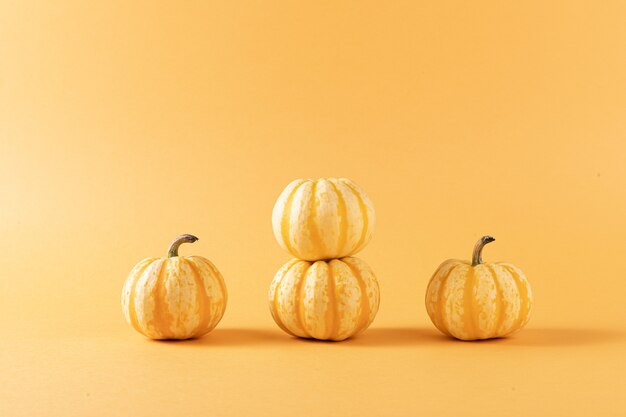 Closeup shot of four pumpkins isolated on orange background