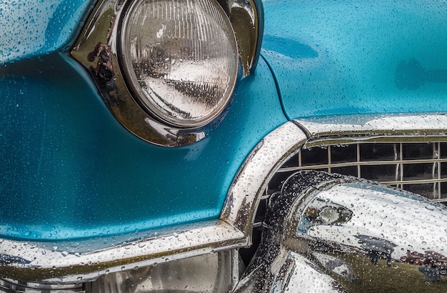 Free photo closeup shot of the front part of a blue car including the lights and the bumper