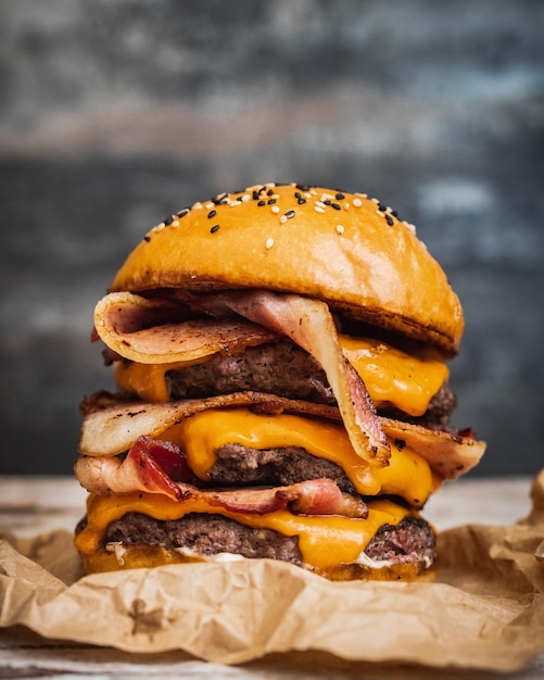 Free photo closeup shot of a giant delicious mouthwatering burger with fried bacon melted cheese and beef